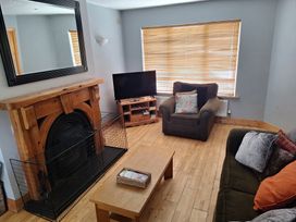 A living room with a fireplace, sofa, and coffee table at 19 River Glen in Curracloe, County Wexford