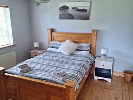 A bedroom with a bed and bedside tables at 19 River Glen in Curracloe, County Wexford