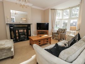 A living room with a fireplace and a television at Tyddyn Goronwy in Talybont