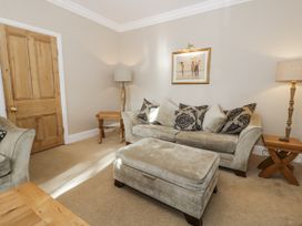 A living room with a sofa and ottoman at Tyddyn Goronwy in Talybont