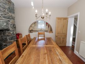 A dining room with a large table and chairs at Tyddyn Goronwy in Talybont