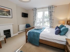 A bedroom with a bed and a television at Tyddyn Goronwy in Talybont