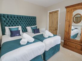 A bedroom with two beds and a mirror at Tyddyn Goronwy in Talybont