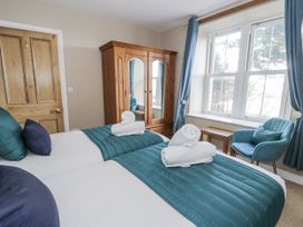 A bedroom with two beds and a wardrobe at Tyddyn Goronwy in Talybont