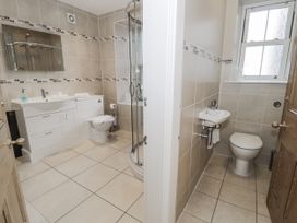 A bathroom with a sink, toilet, and shower at Tyddyn Goronwy in Talybont