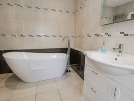 A bathroom with a bathtub and sink at Tyddyn Goronwy in Talybont