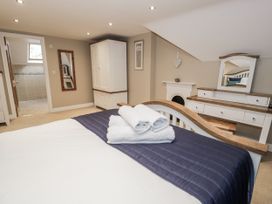 A bedroom with a bed and wardrobe at Tyddyn Goronwy in Talybont