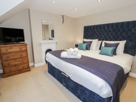 A bedroom with a bed and television at Tyddyn Goronwy in Talybont
