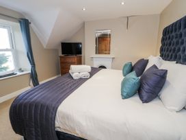 A bedroom with a bed and television at Tyddyn Goronwy in Talybont