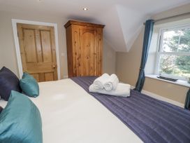 A bedroom with a bed and wardrobe at Tyddyn Goronwy in Talybont