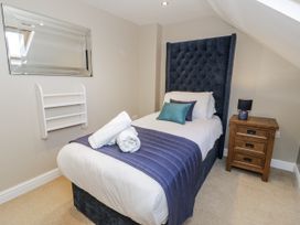 A bedroom with a single bed and bedside table at Tyddyn Goronwy in Talybont