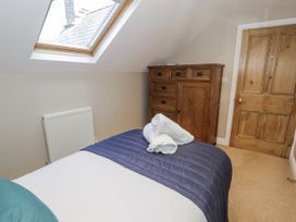 A bedroom with a bed and wardrobe at Tyddyn Goronwy in Talybont