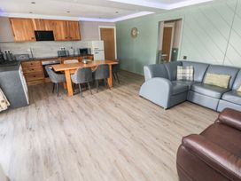 A living room with a kitchen area and dining table at Meadow View in Laugharne
