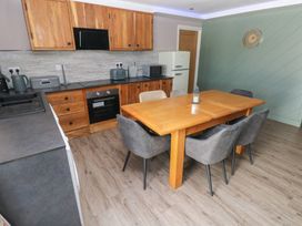 A kitchen with a wooden table and chairs at Meadow View in Laugharne