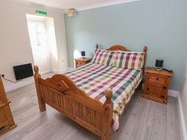 A bedroom with a wooden bed and nightstand at Meadow View in Laugharne
