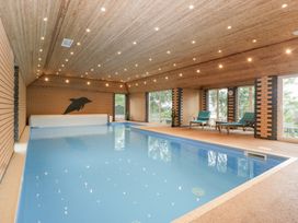 An indoor pool area with chairs and large windows at The Croft in Vowchurch near Peterchurch