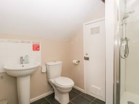A bathroom with a toilet, sink, shower and door at The Croft in Vowchurch near Peterchurch
