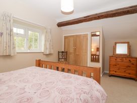 A bedroom with a bed, wardrobe, and window at The Croft in Vowchurch near Peterchurch
