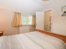 A bedroom with a double bed and a door leading to a bathroom at The Croft in Vowchurch near Peterchurch