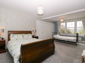 A bedroom with a bed, side table, wardrobe, and window at The Croft in Vowchurch near Peterchurch