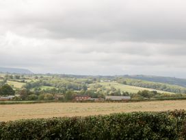 A view of fields and trees with houses in the distance at The Croft in Vowchurch near Peterchurch