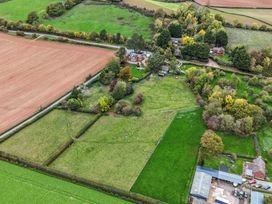 An aerial view of a farmhouse surrounded by fields and trees at The Croft in Vowchurch near Peterchurch