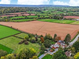 An aerial view of fields and a house with trees at The Croft in Vowchurch near Peterchurch