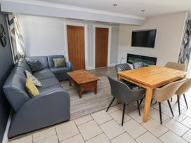 A living room with a sofa, coffee table, dining table and chairs at Dylan's Court in Laugharne