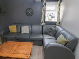 A living room with a grey sofa and wooden coffee table at Dylan's Court in Laugharne