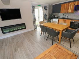 A kitchen with a dining table and appliances at Dylan's Court in Laugharne