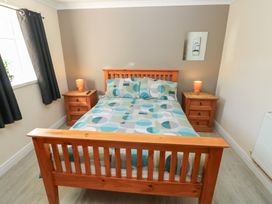 A bedroom with a wooden bed and nightstands at Dylan's Court in Laugharne