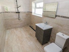 A bathroom with a shower, sink, and toilet at Dylan's Court in Laugharne