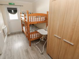 A bedroom with a bunk bed and a high chair at Dylan's Court in Laugharne