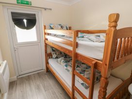 A bedroom with a bunk bed and a door at Dylan's Court in Laugharne