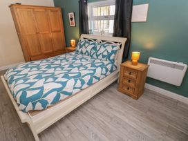 A bedroom with a bed and wardrobe at Dylan's Court in Laugharne