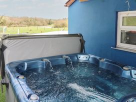 A hot tub with water next to a wall at Dylan's Court in Laugharne