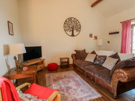 A living room with a television and sofa at Poppy Cottage in Caeathro near Caernarfon