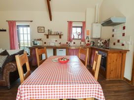 A kitchen with a dining table and chairs at Poppy Cottage in Caeathro near Caernarfon