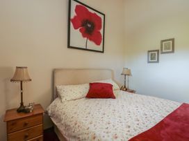 A bedroom with a bed and bedside tables at Poppy Cottage in Caeathro near Caernarfon