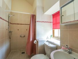 A bathroom with a shower, toilet, and sink at Poppy Cottage in Caeathro near Caernarfon