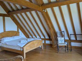 A bedroom with a bed and chair at Hiraeth in Dolau near Llandrindod Wells