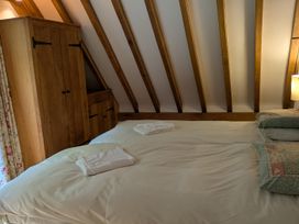A bedroom with a bed and wardrobe at Hiraeth in Dolau near Llandrindod Wells