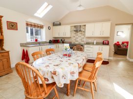 A kitchen with a dining table and wooden chairs at 2 Pines Farm Cottages Ulleskelf