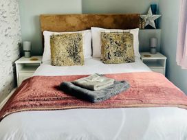 A bed with pillows and blankets at Corvette in Trearddur Bay