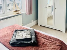 A bedroom with a bed and towels on a blanket at Corvette in Trearddur Bay