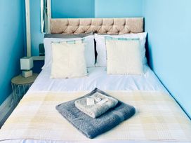 A bedroom with a bed and pillows at Corvette in Trearddur Bay