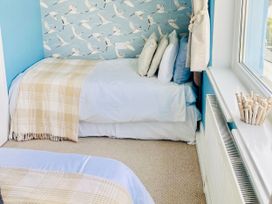 A bedroom with a bed and pillows at Corvette in Trearddur Bay