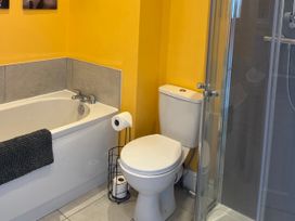 A bathroom with a bath tub and toilet at Corvette in Trearddur Bay