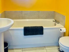 A bathroom with a bathtub, a sink, and a toilet at Corvette in Trearddur Bay