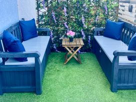 An outdoor seating area with sofas and table at Corvette in Trearddur Bay